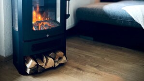 Un poêle à bois se trouve dans une pièce qui contient un lit et une fenêtre.