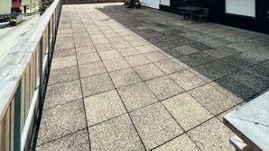 Un vaste espace extérieur doté d’un sol carrelé, de bancs en bois et d’un espace de repos abrité.