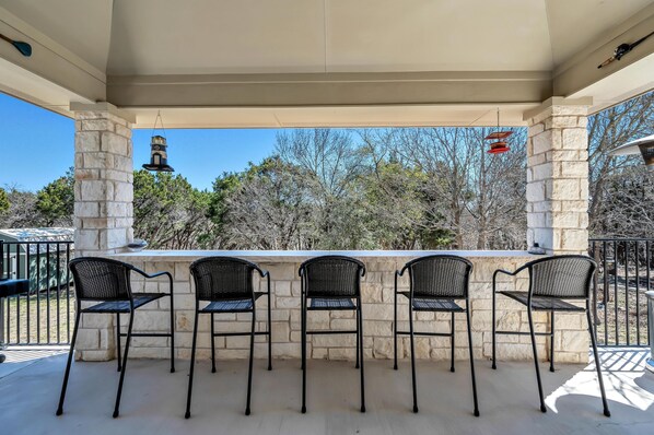 A covered outdoor bar area with stone pillars and black metal chairs. - Lake Access - Private Pool - 2 Acres Retreat (Belton)