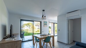 Una sala de estar moderna con comedor, ventanas amplias y vistas al exterior.