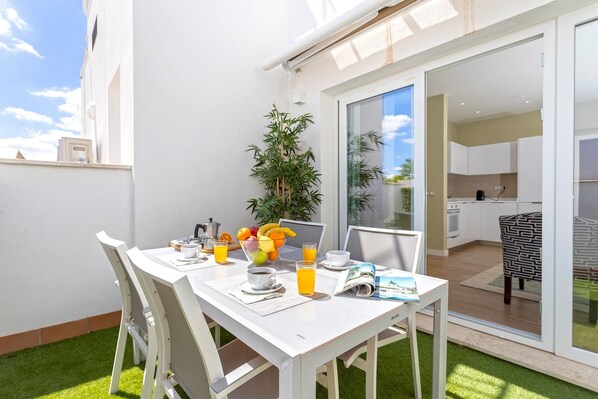 A dining table with chairs, a bowl of fruit, a coffee cup, and a magazine.