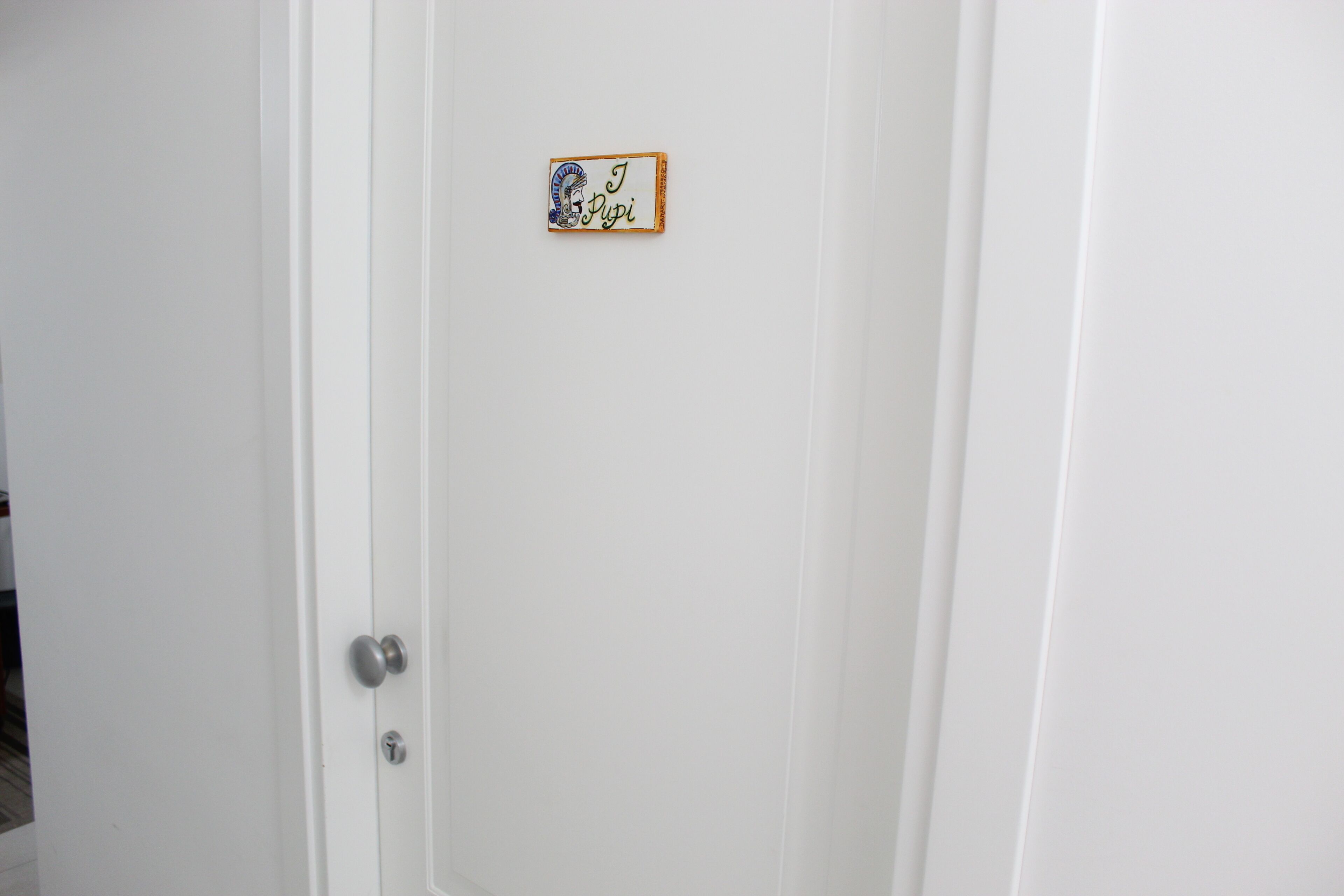 Une porte blanche ornée d’une petite plaque rectangulaire décorative.