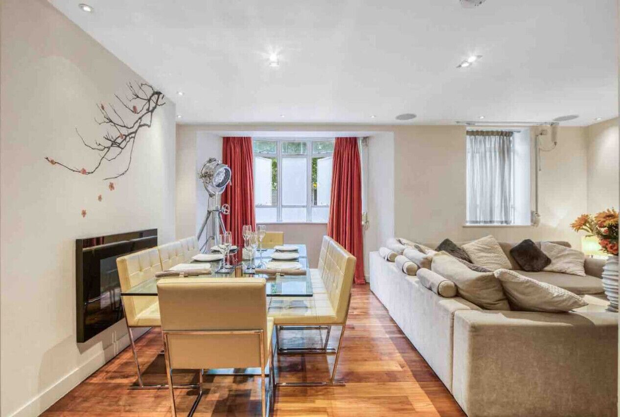 Un salon moderne comprenant un coin repas, un canapé et une cheminée.