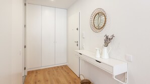 Un baño moderno con un tocador blanco, un espejo grande y un adorno de pared decorativo.