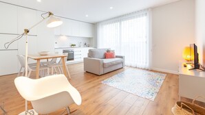A modern living space with a dining area, a sofa, and a kitchen in the background. - Oporto Palace Apartments Five (Oporto)