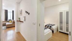 A modern apartment with a living area, a bedroom with a bed and wardrobe, and a small balcony.