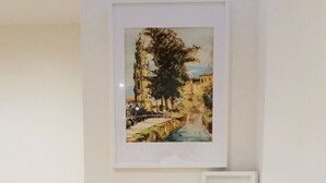 A hallway with a wooden staircase, a framed painting of a street scene, and a small white shelf with a book. - D&S - Crocodile House S. Bento Apartments IV (Oporto)