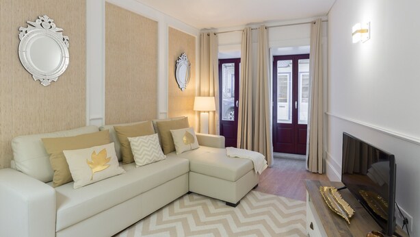 A modern living room with a sectional sofa, a flat-screen TV, and a fireplace.