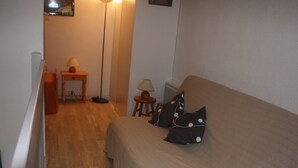 A bedroom with a bed, two pillows, a nightstand, a lamp, and a floor lamp. - 1 Bedroom Villa in SAINT CYPRIEN PLAGE (SAINT CYPRIEN PLAGE)