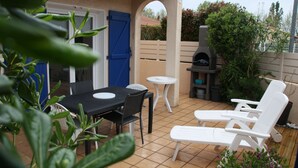 An outdoor patio with a table, chairs, and a barbecue grill. - 1 Bedroom Villa in SAINT CYPRIEN PLAGE (SAINT CYPRIEN PLAGE)