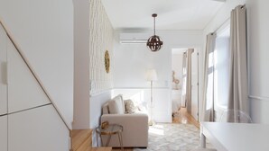 A modern living room with a sofa, a small round table, and a patterned rug.