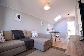 A modern living room with a sofa, a dining table, and a kitchen area. - Lapa 32 - Pedro IV (Oporto)