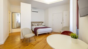 A modern bedroom with a bed, a chair, a table, and a potted plant. - TRY OPORTO - Ponte Dom Luís (Oporto)