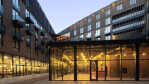 Un edificio moderno con varios pisos, ventanas amplias y balcones.