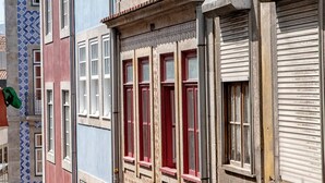 A row of colorful buildings with distinct architectural styles, including a red facade and a blue patterned wall. - Try Oporto Ribeira - Caves Port-Wine (Oporto)