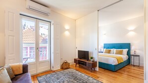 A modern bedroom with a bed, a TV, and a sofa. - D&S - Porto São Bento Apartments III (Oporto)