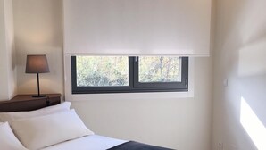Une chambre à coucher avec un lit, une fenêtre et une lampe.