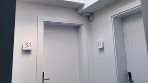 Une chambre d’hôtel moderne dotée de deux portes, chacune étant signalée par un numéro.