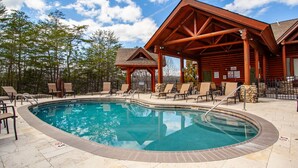 A pool area with lounge chairs and a wooden pavilion. - The Bear Paw Palace - Mtn View & Community Pools! (Pigeon Forge)