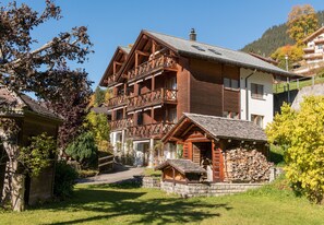 Ein traditionelles Chalet mit Holzhauserscheinigung, mehreren Balkonen und einem Steinfundament.