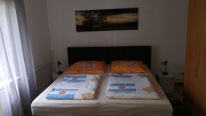 Ein Doppelbett mit zwei Kissen, jedes mit einem Sonnendesign und der Zahl 3.