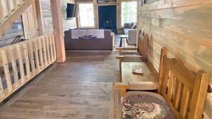 Un interior de madera con una escalera, un sofá y una mesa de comedor.
