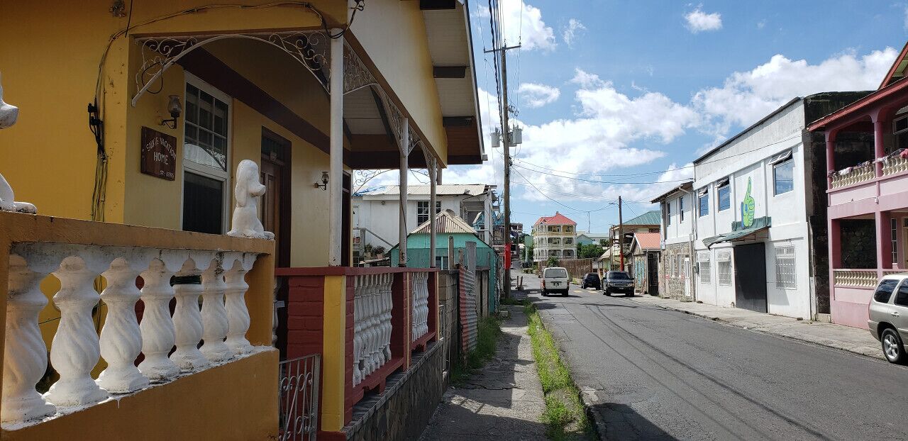 A street view with buildings, a sidewalk, and a parked car.