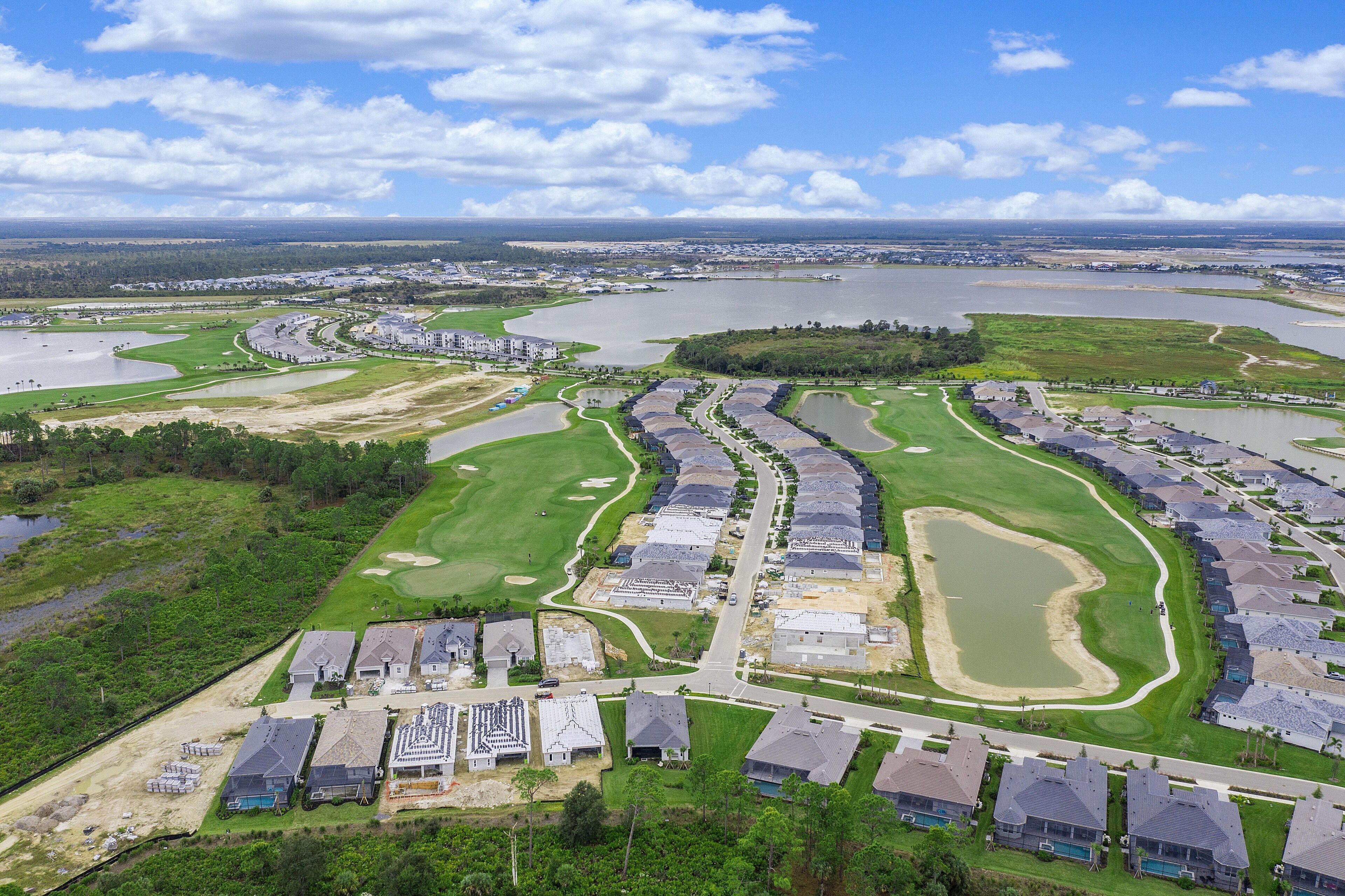 Vista aérea de una zona residencial con casas, calles y una gran masa de agua.