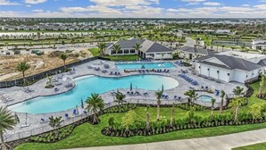 A resort with a large pool, multiple buildings, and a well-maintained lawn. - Babcock Ranch Golf Bundle Condo in Babcock National (Punta Gorda)