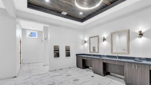 A modern bathroom with marble flooring, dual sinks, and wall-mounted mirrors. - Babcock Ranch Golf Bundle Condo in Babcock National (Punta Gorda)