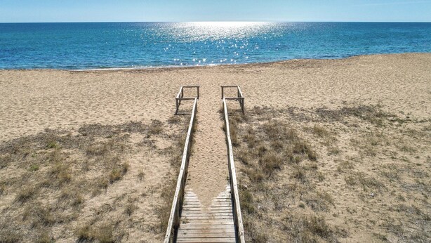 A sandy beach with a wooden walkway leading to two empty beach chairs. - Villa Bella Giulia by BarbarHouse (Maruggio)
