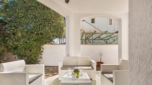 A white wicker outdoor seating area with a table, chairs, and a potted plant. - Villa Bella Giulia by BarbarHouse (Maruggio)