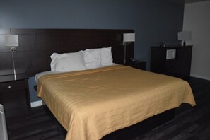 A hotel room with a bed, nightstands, a dresser, and a lamp. - PLYMOUTH MOTOR LODGE (Terryville)