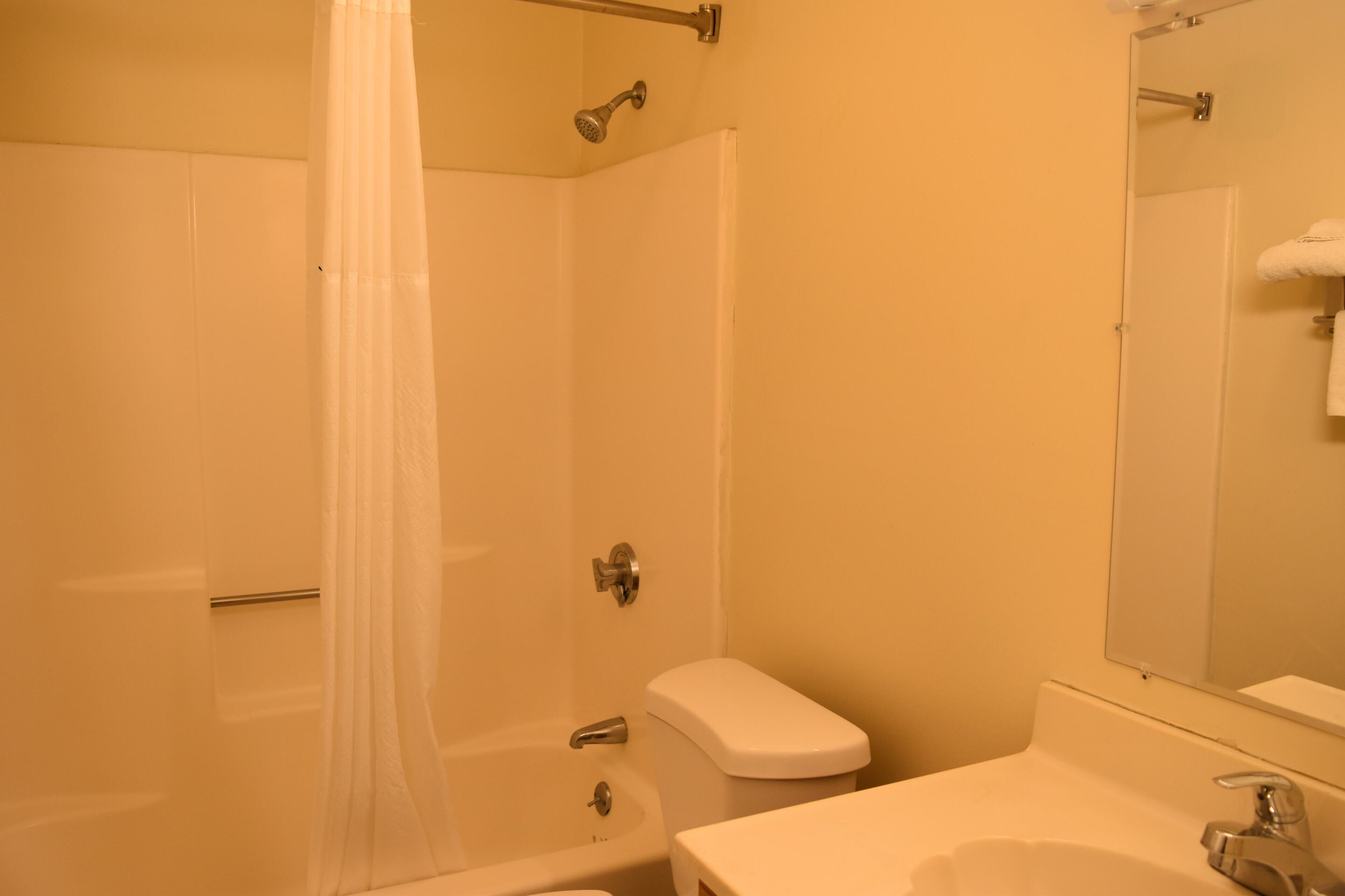 A bathroom with a bathtub, toilet, and sink.