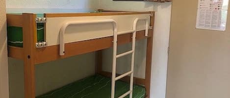 A bunk bed room with a window and a door.