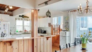 Une cuisine dotée de meubles en bois, d’un îlot central et d’un coin repas avec une table et des chaises.