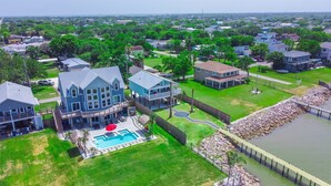 A large house with a pool, surrounded by a fence and a dock. - Waterfront Bay Views | Beautiful Private Pier (San Leon)