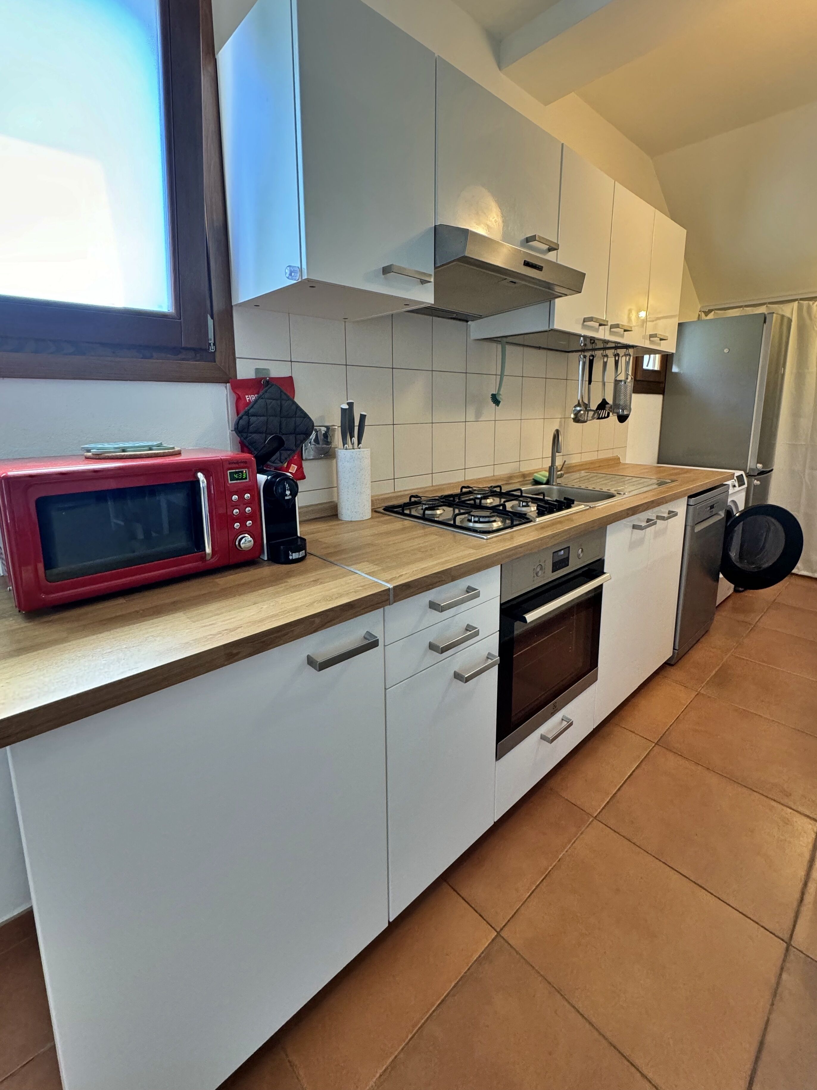 A modern kitchen with a microwave, stove, oven, and a refrigerator.
