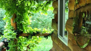 Una cabaña de madera con una terraza, una ventana y un cartel de bienvenida.