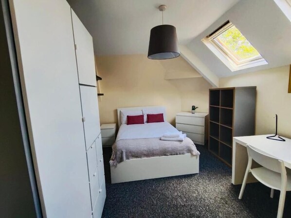A bedroom with a bed, a desk, a wardrobe, and a skylight. - Abbeyfield Guesthouse (Liverpool)