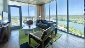 Ein geräumiges Wohnzimmer mit einem großen Fenster und Blick auf einen Fluss und Grünflächen.