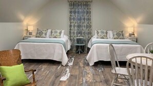 Une chambre avec deux lits, une petite table et une chaise.