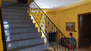 Una escalera con barandilla de metal negro que conduce a un rellano.