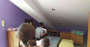 A room with purple walls, a wooden desk, a bed with a yellow pillow, and a child playing with a toy. - Vacation home in Calabria - Holiday home in Calabria (Fuscaldo)