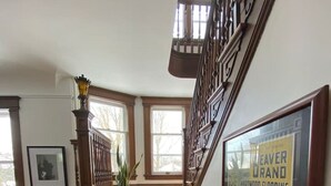 A staircase with wooden steps and a handrail, leading to a landing with a framed sign. - Eddie Manor: 1907 Gem in Downtown Meaford (Meaford)