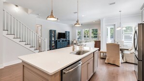 A modern kitchen with a central island, stainless steel appliances, and a built-in dishwasher. - Posh Home + Private Pool, LSV, Putt & Basketball (Seacrest)