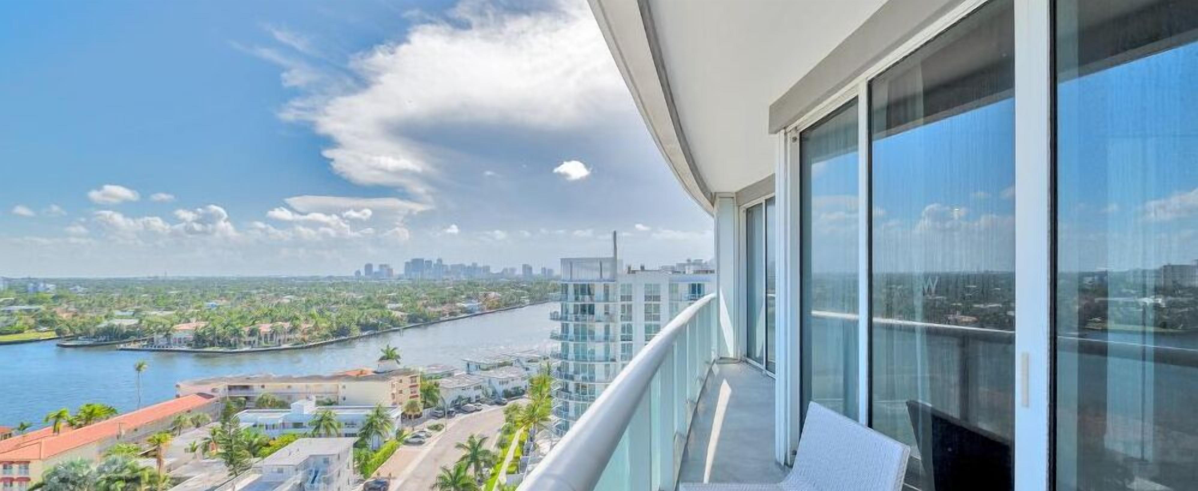 Een balkon met uitzicht op een rivier en stadsbeeld.