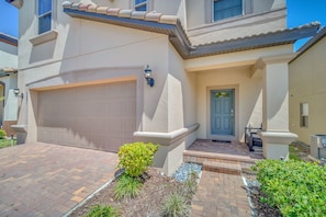 Stucco exterior home with a spacious garage and inviting porch area.