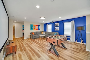 Relax in this stylish living room with a sofa, coffee table, and foosball table.