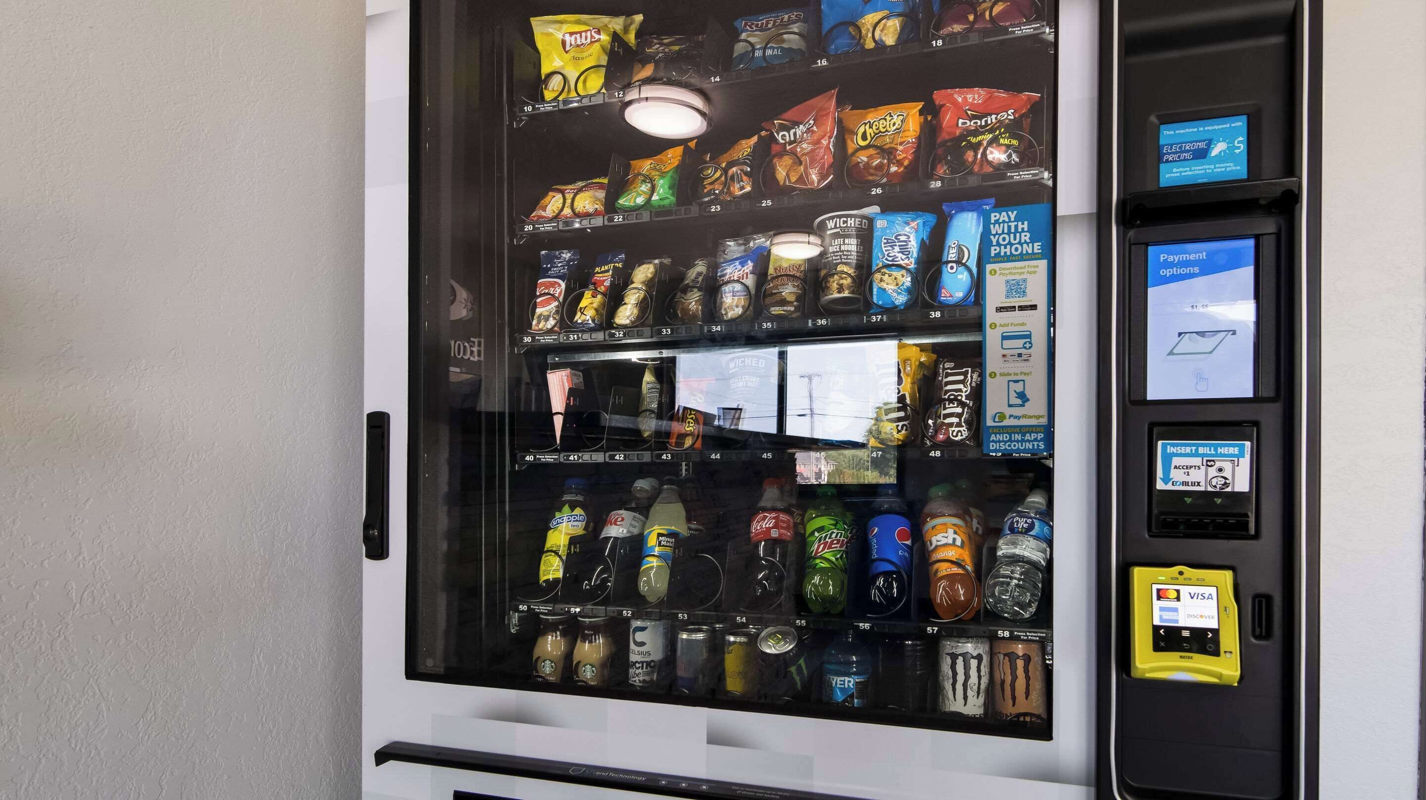 A vending machine with snacks, drinks, and a payment terminal.